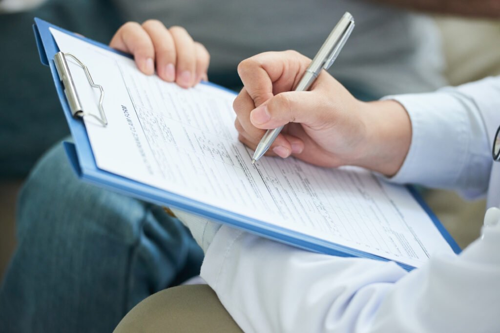 Hands of a professional filling out forms on a clipboard for as-built plans and site assessments